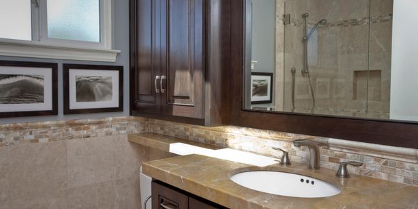 Custom cabinets, marble wall and shower tile, marble floors, frameless glass for remodeled bathroom