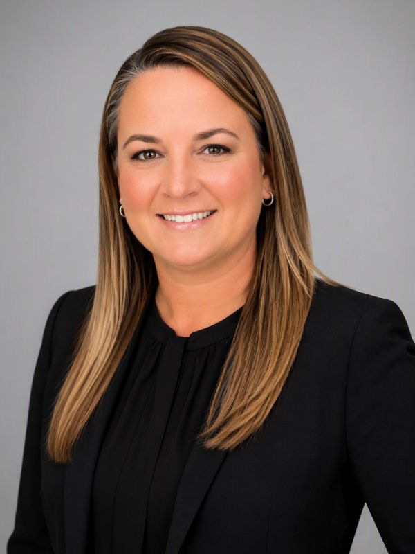 Professional woman in black blazer smiling.