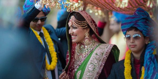 Indian bride under traditional canopy at wedding.