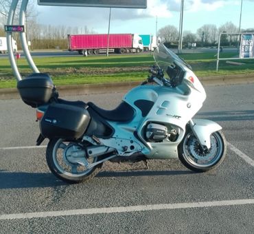 White touring motorcycle parked in an outdoor lot under clear sky.
