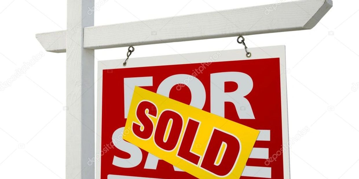A sold sign hanging over a for sale sign on a white post.