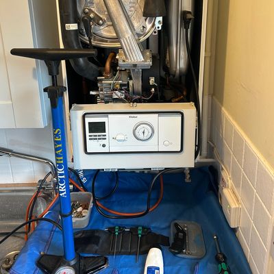 A boiler system with tools and a pump nearby for maintenance.