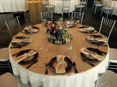 Ten-seater roundtable with cutlery, plates, and wine glasses for professional events.