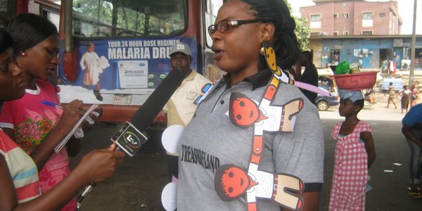 A woman speaking to members of the press