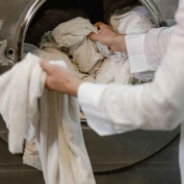 Person unloading towels from washing machine.