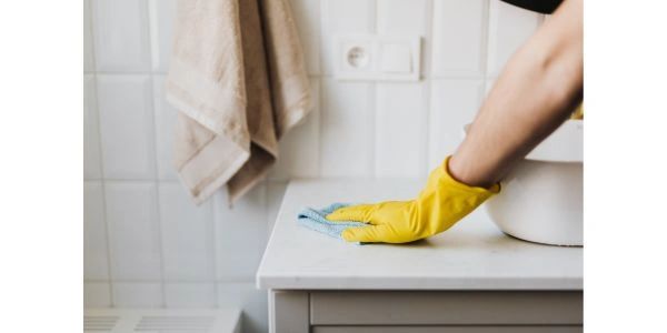 shows a woman cleaning a countertop using Eclipse Household Cleaning Pods