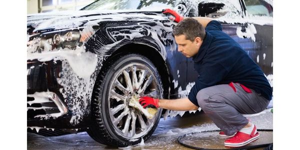 Shows man washing his car using the Eclipse Car Wash cleaning pods 