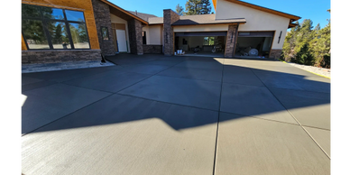 Newly poured concrete driveway in front of a modern house.