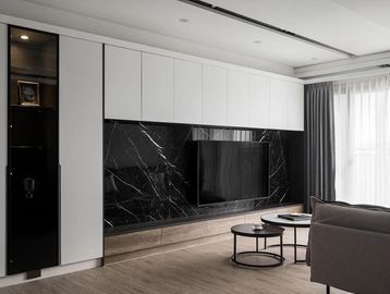 Modern living room with black marble TV wall and minimalist furniture.