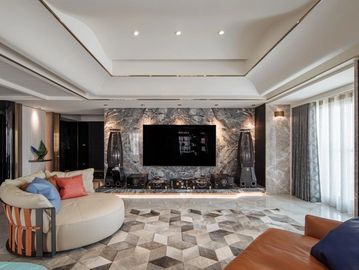 Modern living room with marble wall and curved sofa.