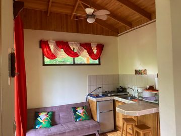 Cozy kitchen and living room with wooden ceiling.