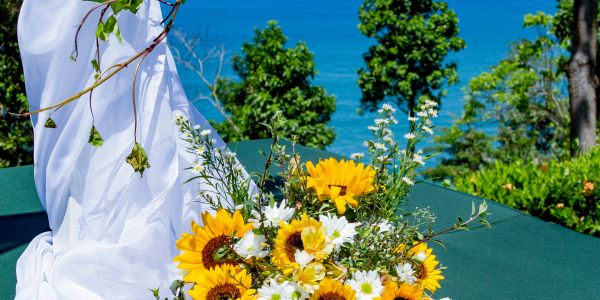 Yellow and white flowers near a blue ocean background.