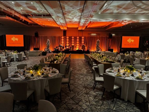 Elegant banquet hall with warm lighting and decorated round tables for a formal event.