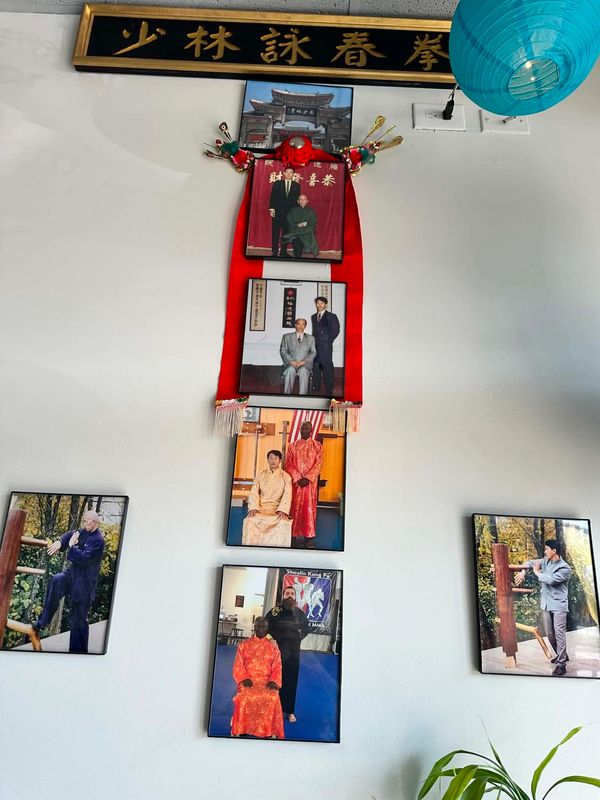Wall display of kung fu photos with Chinese calligraphy and decorations.