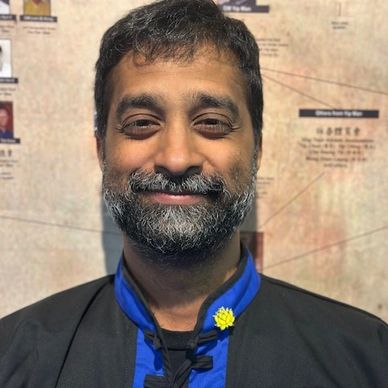 Man with beard smiling at the camera.