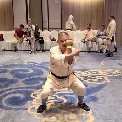 Man practicing martial arts in traditional attire indoors.