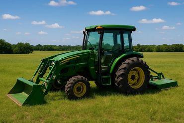 Green tractor parked on a grassy field under a blue sky.