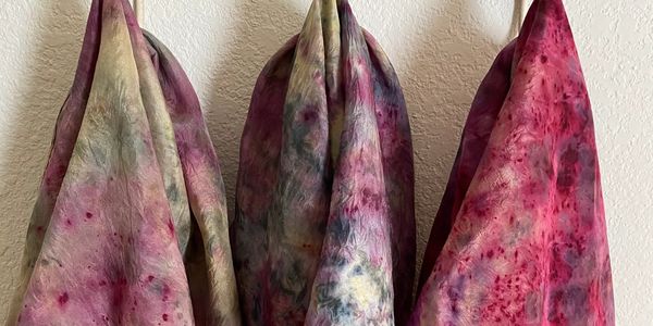 Three colorful, tie-dyed fabrics hanging.