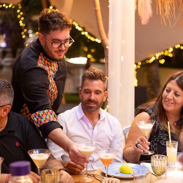 Friends enjoying cocktails together at a lively dinner party.