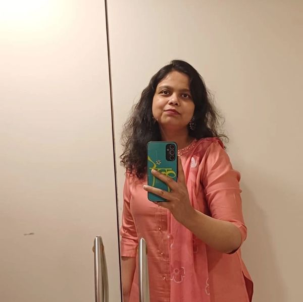 Woman in a peach traditional outfit taking a mirror selfie.