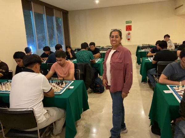 Mujer sonriendo en torneo de ajedrez.