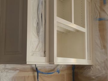 Kitchen cabinets and countertop covered for painting preparation.