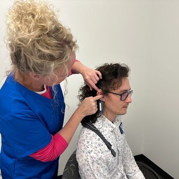 Audiologist using a real-ear measurement system to verify Bluetooth hearing aids.