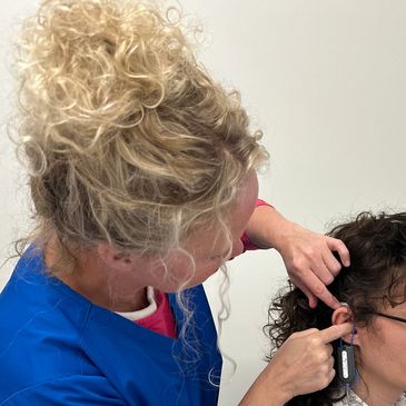 Audiologist using a real-ear measurement system to verify Bluetooth hearing aids.