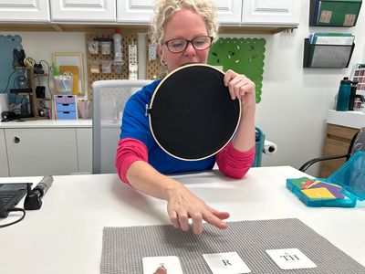 Dr. Cara, audiologist/owner at Rainbow Audiology, treating person for auditory processing disorder.