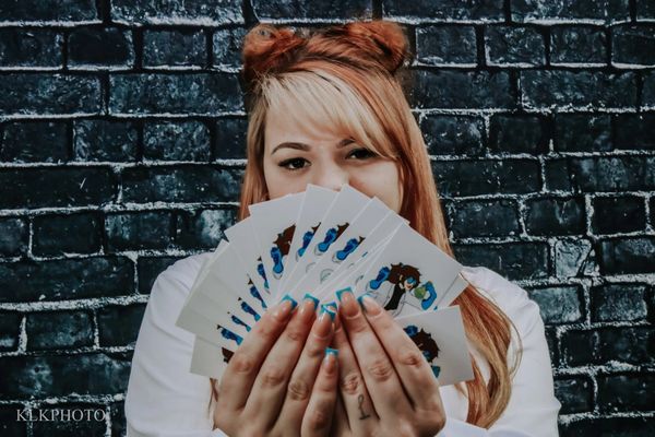Woman holding fanned cards with cartoon designs.
