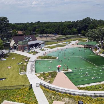 A community swimming pool with people enjoying a sunny day.