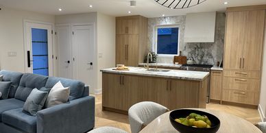 Modern open kitchen with wooden cabinets and a cozy living area.