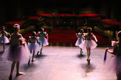 ballet dancers posed onstage looking out to the audience