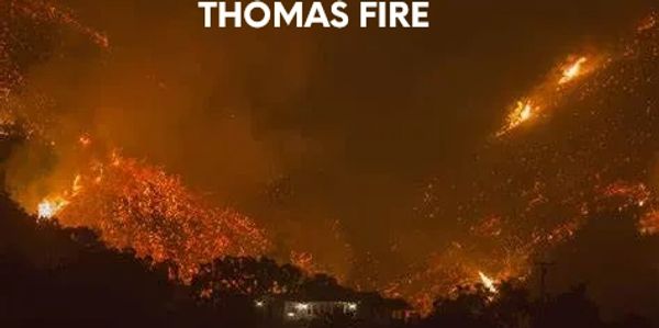 Wildfire burning intensely on a hillside at night labeled Thomas Fire Dec. 2017.