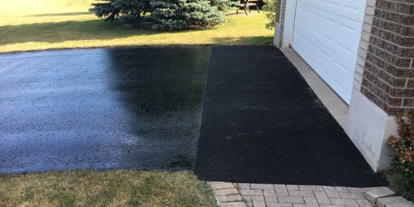 A residential driveway that has been repaired and sealed using oil-based asphalt sealer