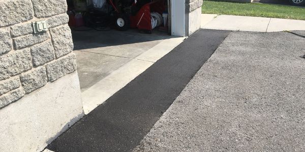 A new asphalt ramp was installed to eliminate the drop out of the garage. 