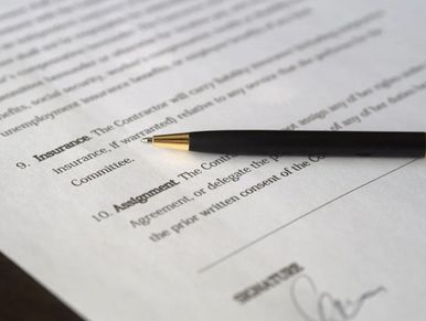 a page of a contract with a pen lying on top