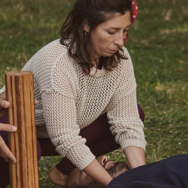 Femme pratiquant un soin ou massage sur un homme allongé.