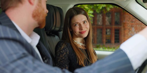 Woman smiling at man in a car.