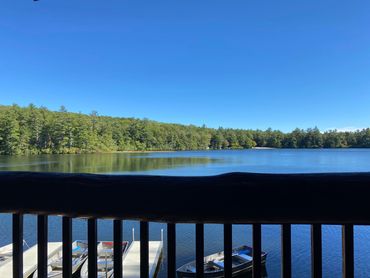takodah lake serene row boats tress forest railing dock