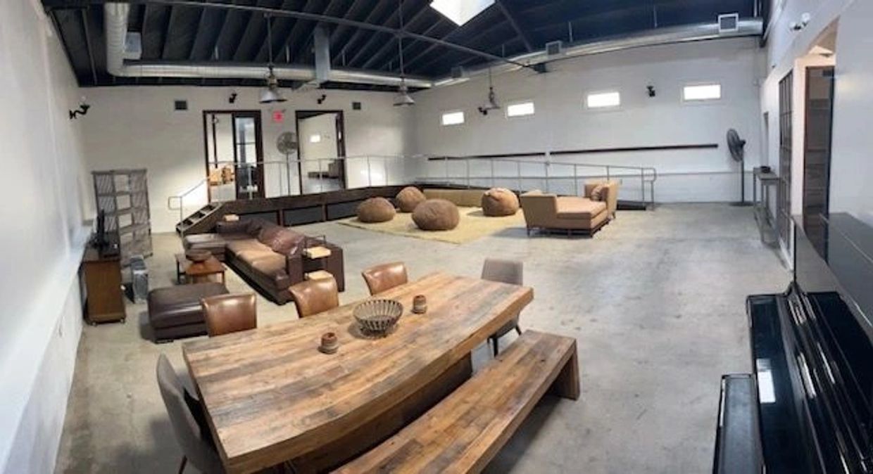 Spacious modern lounge with wooden table and bean bags.