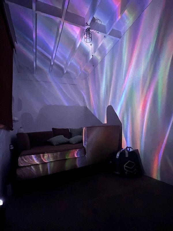Colorful light patterns on the floor and walls near a couch.