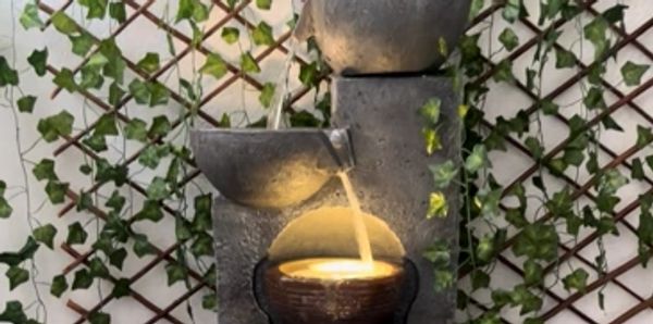 A tabletop water fountain with a lit candle.