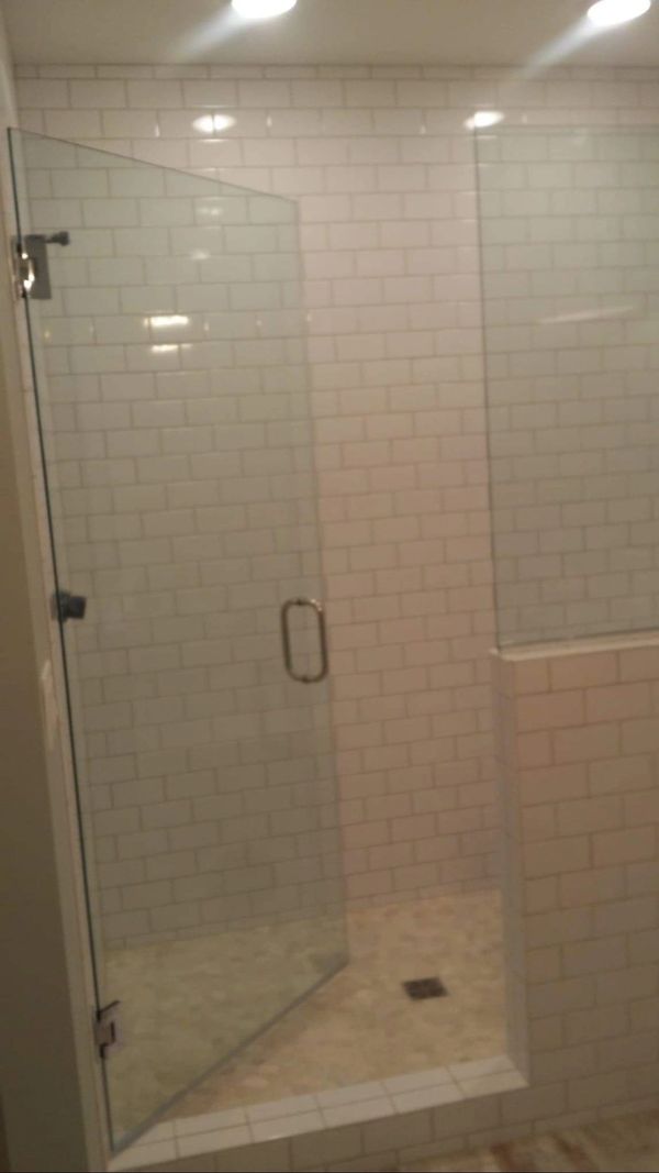 Frameless shower with swinging door.