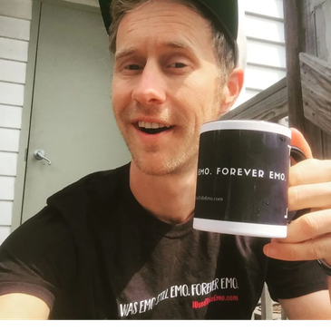 Man holding a black mug with emo-themed text.