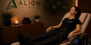 Woman relaxing in a wellness center wearing compression therapy gear.