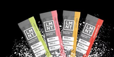 Four LMNT electrolyte drink mix packets with different flavors and salts.