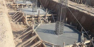 Construction site with concrete foundations and steel reinforcements.