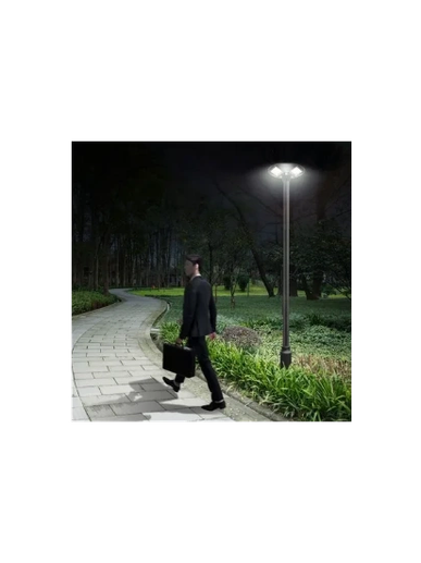 Man in suit walking on a lit path at night.