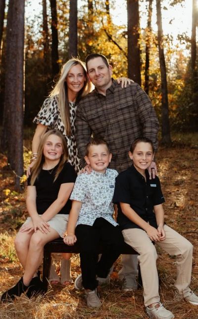 Family portrait outdoors in autumn with smiles and hugs.